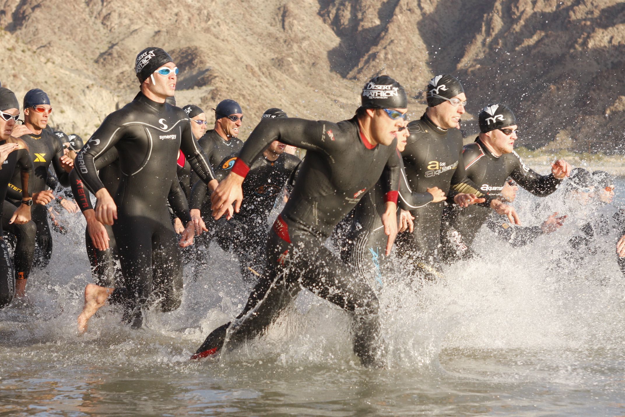 Group of swimmers running towards sea to begin a race 