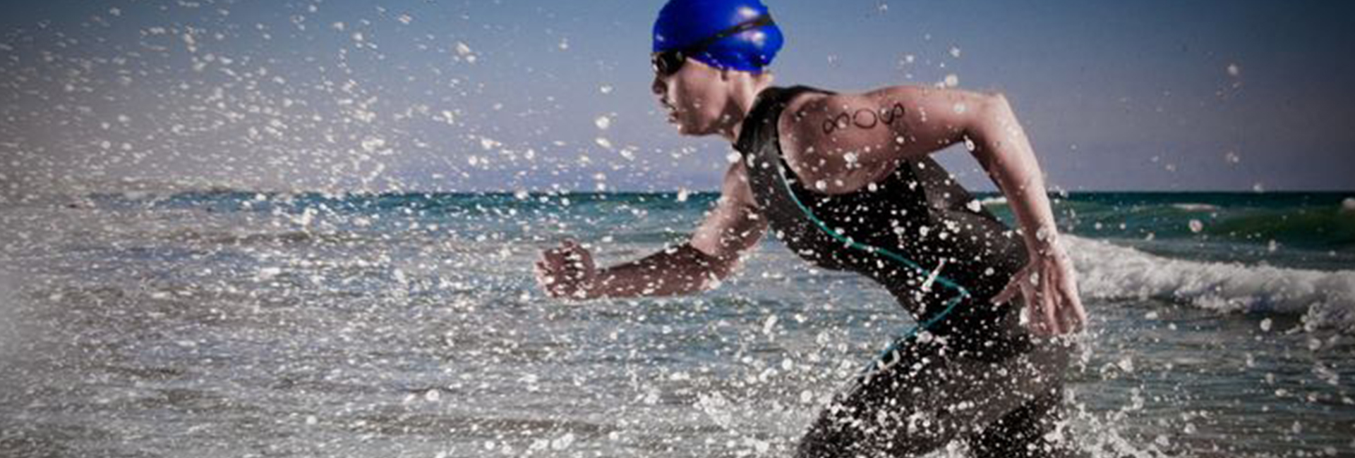 Athlete swimmer running through the water to begin the race