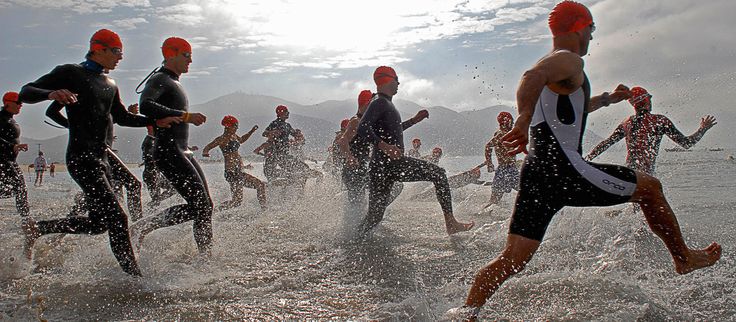Athletes running through water on beach