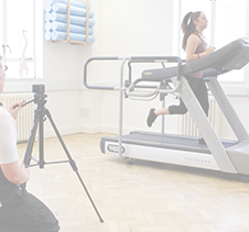 Physiotherapist recording running performance on treadmill