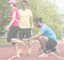 Running Coach providing support for Athlete runners on running track