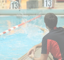 Swimming Coach observing swimmers racing in a pool