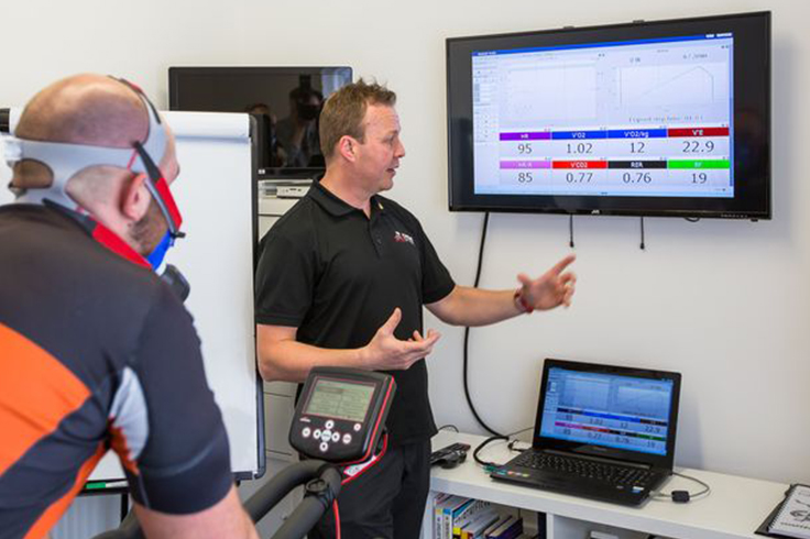 Sports Scientist showing Athlete cyclist results after monitoring performance