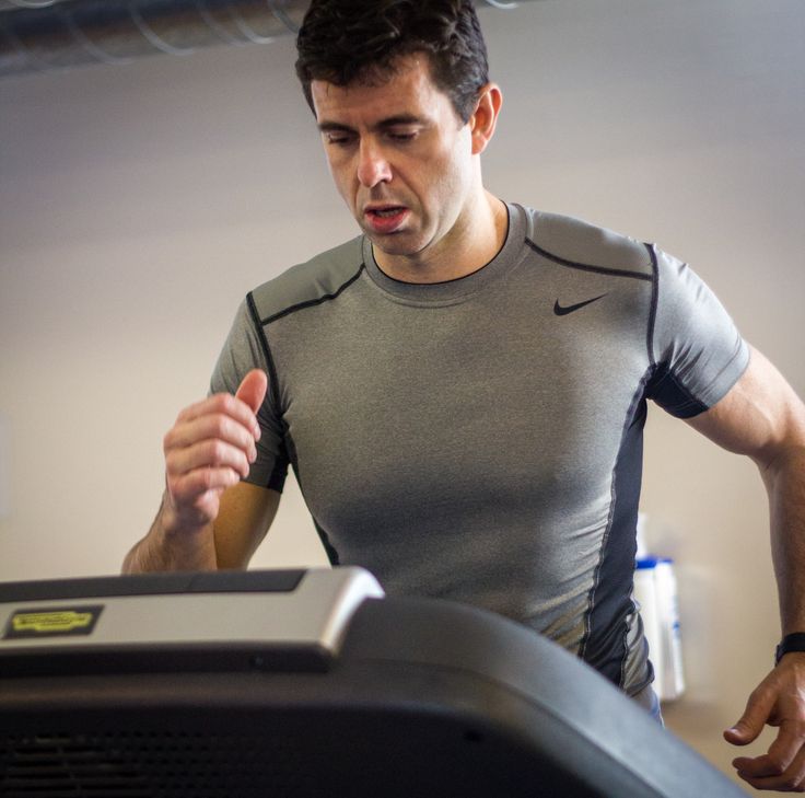 Athlete runner monitoring performance on treadmill