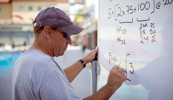 Triathlon Coach writing down notes on whiteboard