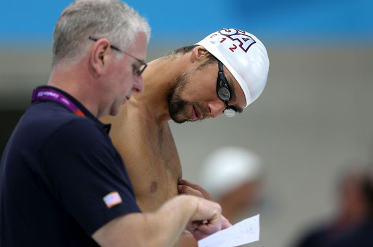 Swimming Coach discussing techniques with athlete swimmer